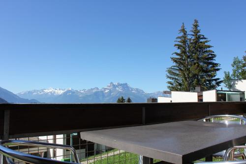 a table on a balcony with a view of mountains at Leysin Lodge in Leysin