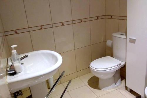 y baño con aseo blanco y lavamanos. en Casa da Oliveira en Milhão