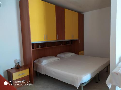 ポルト・チェザーレオにあるMonolocale relaxの黄色のキャビネット付きの部屋のベッド2台