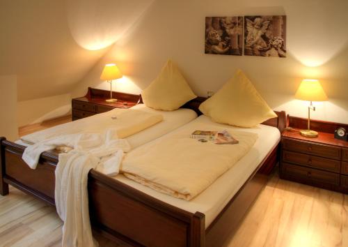 ein Schlafzimmer mit einem großen Bett mit zwei Nachttischen in der Unterkunft Aparthotel Jägerhaus in Willingen
