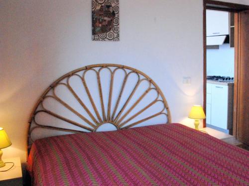 a bedroom with a bed with a red bedspread at Apartment Il Seccione-1 by Interhome in Portoferraio