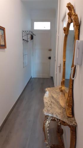 un miroir assis sur une table à côté d'un couloir dans l'établissement Apartment Palais de Coppet, à Nice