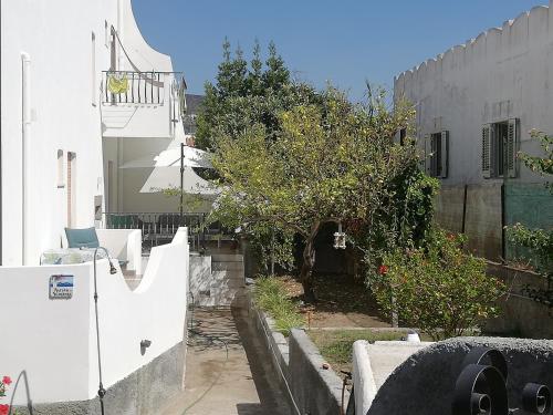 an alley way with a white building and trees at Villetta Aurora in Lipari