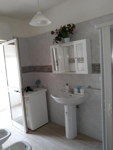 トッレ・モッツァにあるAppartamento Alba vista spiaggiaのバスルーム(白い洗面台、鏡付)