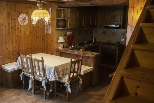 kuchnia ze stołem, krzesłami i zlewem w obiekcie Chalet indipendente in centro a Valtournenche w mieście Valtournenche