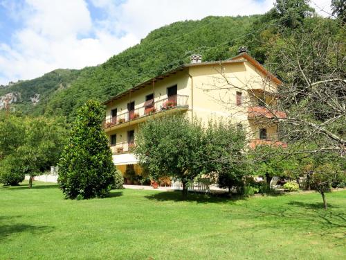 a large building with trees in front of a mountain at Apartment Natalie - BLU170 by Interhome in Cocciglia