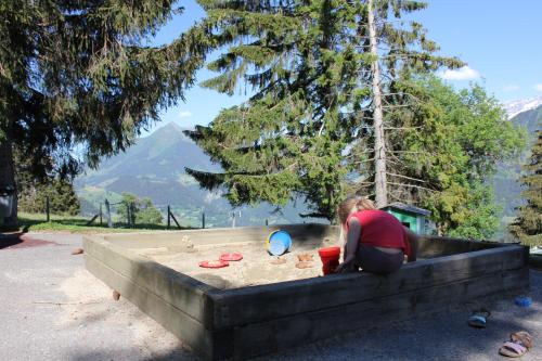 a woman is playing in a sandbox in the sand at Leysin Lodge in Leysin