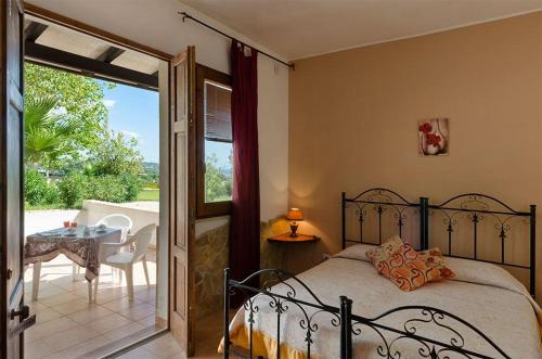 a bedroom with a bed and a balcony with a table at Tenuta Li Fani Residence Hotel in Marina di Pescoluse