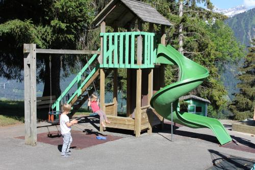 two children playing on a playground with a slide at Leysin Lodge in Leysin