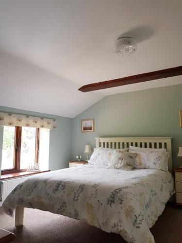 a bedroom with a large bed with a floral bedspread at 2 Barge Cottage in Narborough