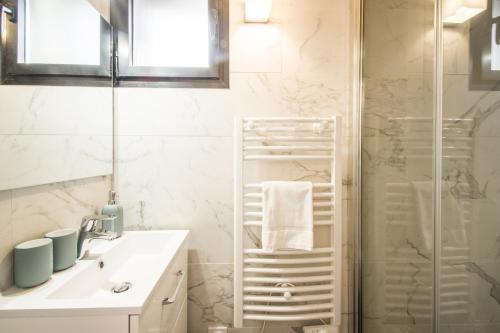 une salle de bain avec un lavabo blanc et une douche dans l'établissement LE DIEBOLD - Appartement 2 chambres climatisé, à Toulouse