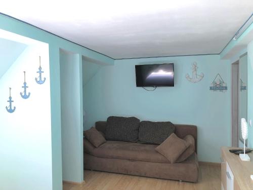 a living room with a couch and a tv on the wall at MaximilianHaus in Zell an der Mosel