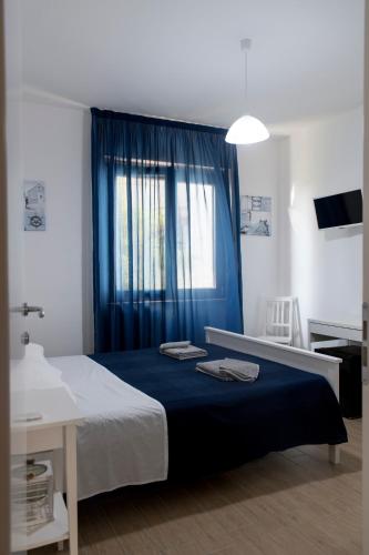 a bedroom with a bed with a blue curtain at L'oasi di Giorgia in Cittadella del Capo