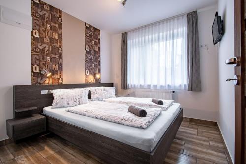 豪伊杜索博斯洛的住宿－Garden Lux Apartman，一间卧室设有一张大床和一个窗户。