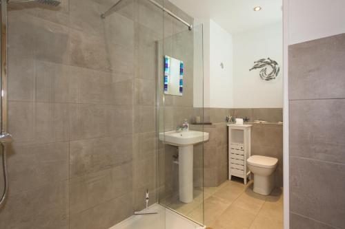 a bathroom with a shower and a sink and a toilet at The Loft in St Ives