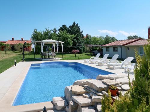 a swimming pool with chairs and a gazebo at Holiday Home Andrea - LBN415 by Interhome in Labin