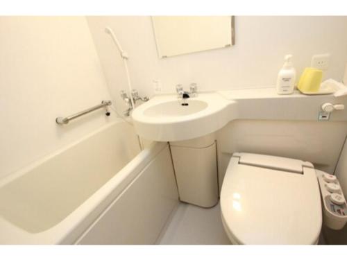 uma casa de banho branca com um WC e um lavatório em Mizusawa Ground Hotel - Vacation STAY 85019 em Oshu