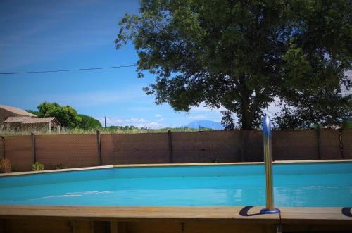 a swimming pool with a stick in the middle of it at Ô chalets de Provence in Suze-la-Rousse