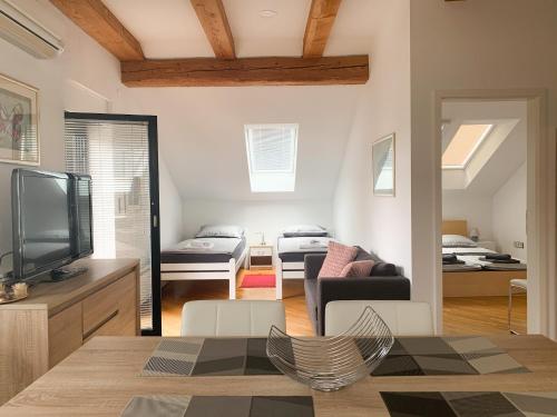 een woonkamer met een televisie en een woonkamer met een bed bij Ela's Apartment in Komenda