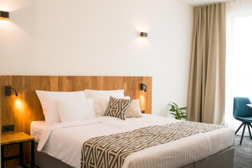 um quarto com uma cama grande e uma cadeira azul em Roko Garni Hotel em Brezovica