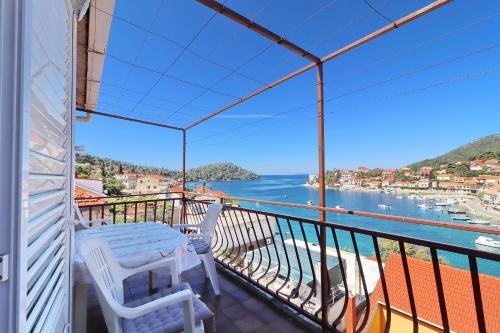 einen Balkon mit einem Tisch und Stühlen sowie Blick auf das Wasser in der Unterkunft Apartments Peselj in Smokvica