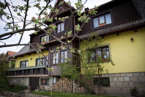 a yellow and brown house with a tree at Śmietanówka Agroturystyka in Krzczonów