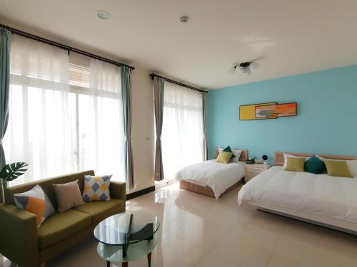 ein Wohnzimmer mit 2 Betten und einem Sofa in der Unterkunft 紅築民宿 in Jincheng