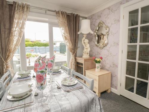 a dining room with a table and a window at Sandpiper in Dumfries