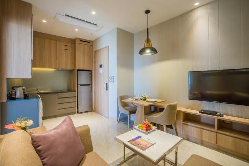 a living room with a table and a kitchen at SKYVIEW Hotel Bangkok - SHA Extra Plus in Bangkok