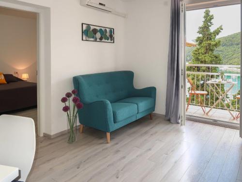 a living room with a blue chair and a window at Apartment Boris - RAC160 by Interhome in Raša