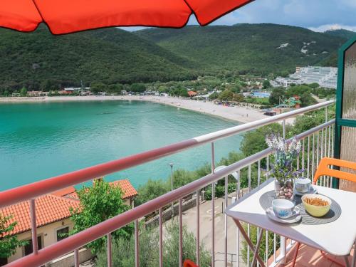 a balcony with a table and a view of a beach at Apartment Boris - RAC160 by Interhome in Raša