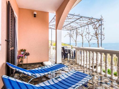 Un balcón con sillas azules y vistas al océano. en Apartment Magdalena - MOD118 by Interhome en Plomin