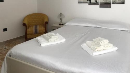 a white bed with towels on top of it at Casa Vacanze Zarinu Orgosolo in Orgosolo