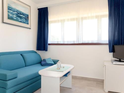 un soggiorno con divano blu e tavolo di Apartment Jurkovic - NJI100 by Interhome a Njivice