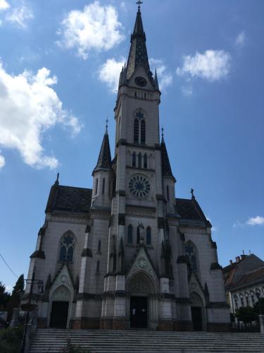 a church with a tower with a clock on it at Gábriel Apartman in Kőszeg