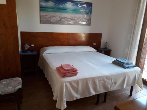 1 dormitorio con 1 cama con toallas en Canne Al Vento, en Teulada
