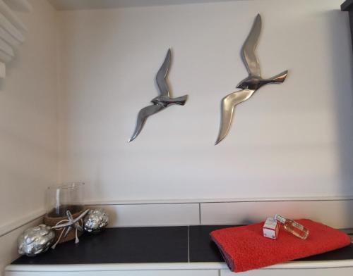 three birds hanging on a wall above a counter at FeWo Hage in Langelsheim