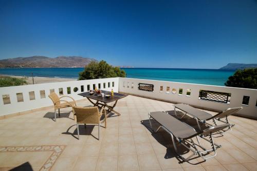 a patio with a table and chairs and the ocean at Vasso Apartments 3 in Kissamos
