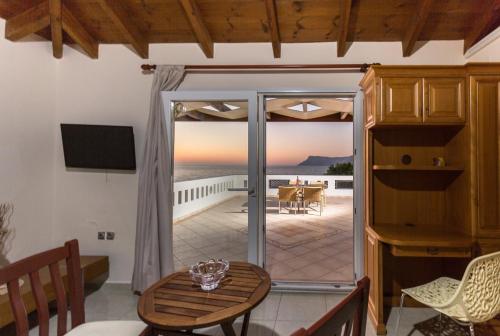 a living room with a table and a sliding glass door at Vasso Apartments 3 in Kissamos