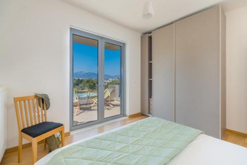 a bedroom with a bed and a chair and a window at Your Home2b in Paianía