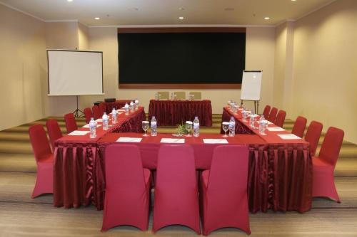 a conference room with a long table and red chairs at Vrata Hotel Yogyakarta in Kalasan