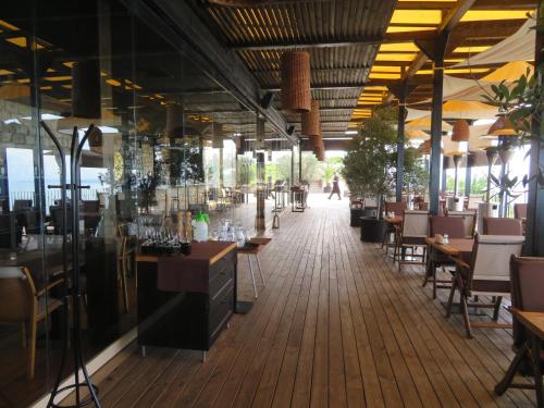 a restaurant with tables and chairs and people walking in the distance at Луксозни Апартаменти Калиакрия - Luxurious Apartments in Kaliakria Resort in Topola
