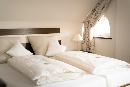 two white beds in a bedroom with a window at Wein-Domizil Brennofen in Ilbesheim