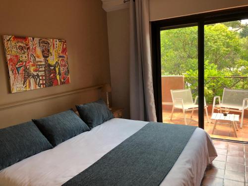 a bedroom with a bed and a view of a patio at Les Jardins de Cassis in Cassis