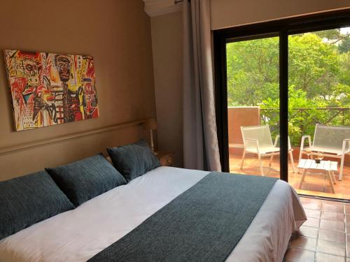 a bedroom with a bed and a view of a patio at Les Jardins de Cassis - Parking Gratuit & Piscine Chauffée in Cassis