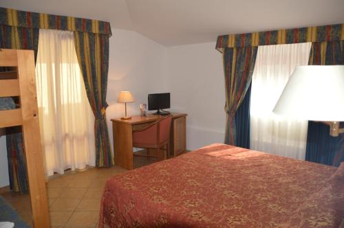 a bedroom with a bed and a desk with a lamp at Hotel Ristorante Antica Marina in Nicotera Marina