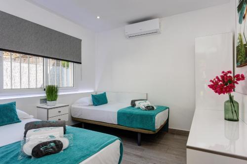 a hotel room with two beds and a window at Villa El Ranchito By Seric, 15' walking to the beach in Torremolinos