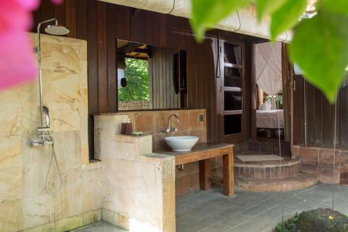 a bathroom with a sink and a shower at Rasasvada cottages in Uluwatu
