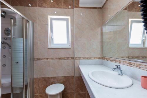 a bathroom with a sink and a shower and a toilet at Vasso Apartments 3 in Kissamos