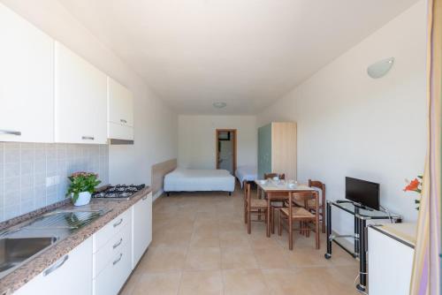 a kitchen with a table and a room with a bed at Club del Sole Stork Family Collection in Giulianova
